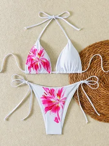 Detailansicht des Blumendrucks auf einem weißen Halter-Bikini-Set mit seitlichen Bändern