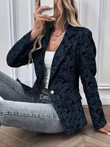 Detalle de un blazer vintage para mujer con estampado jacquard floral y botón dorado