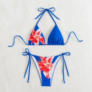 Blauer zweiteiliger Bikini mit lebhaftem rotem Blumenprint auf weißem Hintergrund