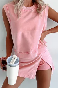 Close-up detail of a pink acid-washed sleeveless sweatshirt and matching wrap skirt set