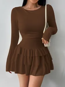 Detail view of brown long-sleeved dress featuring layered ruffle skirt and slim fit.