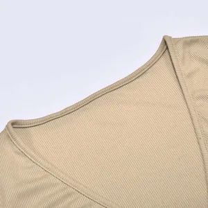 Detailed macro view showing the ribbed knit texture and V-neckline of a beige women's top