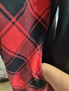 Detalle de primer plano de un práctico bolsillo lateral en un vestido de cuadros rojos y negros.