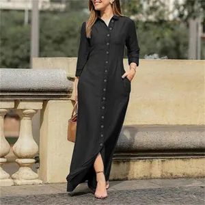 Detail of a black long-sleeve button-down denim maxi dress with a turn-down collar.