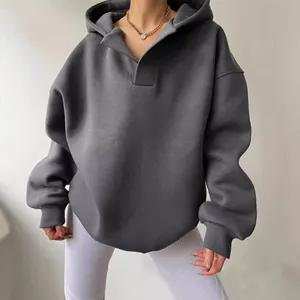 Close-up of a women's oversized dark grey V-neck hoodie showing fabric texture and fit