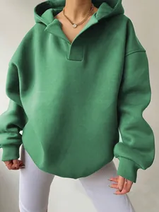 Close-up detail of green oversized hoodie with V-neck hood and ribbed cuffs fabric