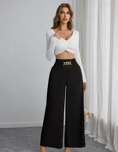 Gedetailleerd overzicht van zwarte broek met hoge taille en gouden kettingdecor