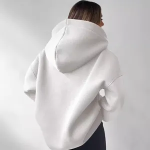Detailansicht der Rückseite eines weißen Oversized-Damen-Kapuzenpullovers mit weichem Stoff.
