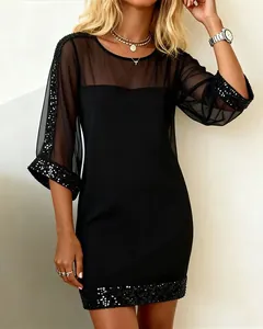 Slim fit black mini dress with sheer mesh sleeves and sparkling sequin trim details.
