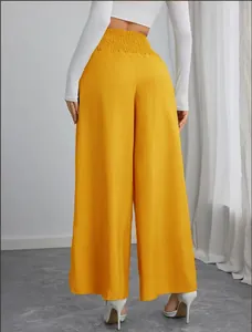 Gedetailleerd achteraanzicht van een knalgele wijde broek met hoge taille en elastiek