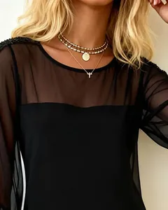 Close-up of elegant black mesh slim-fit dress with sequin shoulders and long sleeves