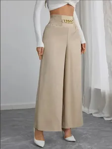 Detail van een wijde broek met hoge taille, voorzien van een gouden ketting en elastische taille.