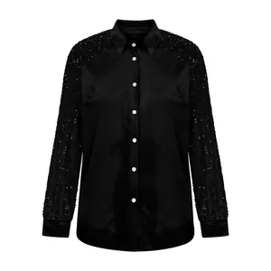 Front view of black velvet shirt featuring sequined long sleeves and white buttons