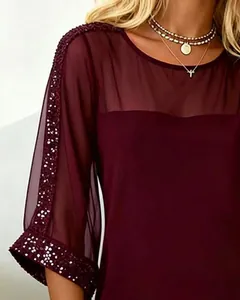 Close-up detail of burgundy mesh dress with sparkling sequin embroidery on sleeves