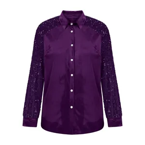 Close-up of a purple velvet shirt featuring sparkling sequin sleeves and a button-down front.