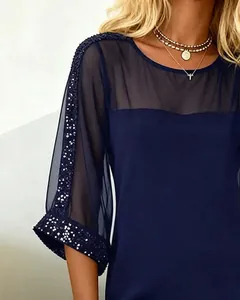 Close-up of navy blue dress featuring sheer mesh sleeves and silver sequin accents