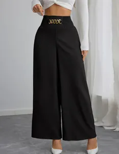 Detail van de zwarte damesbroek met wijde pijpen, hoge taille en gouden ketting