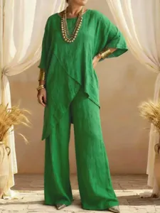 Full view of green linen two-piece set with asymmetrical top and wide-leg trousers