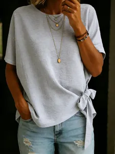 Detail view of a light gray loose T-shirt featuring a stylish side knot at the hem.