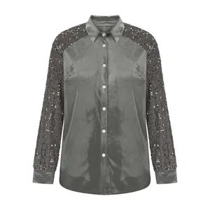 Detailed view of grey velvet blouse showing sparkling sequin sleeves and button closure