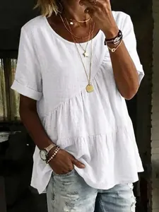 Detailed view of women's white tiered cotton linen tunic top featuring a relaxed round neck.