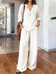 Detail view of a woman wearing a white loose cotton-linen long sleeve set in a bright room