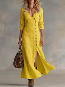Close-up of a yellow linen long-sleeved dress with button placket and front slit.