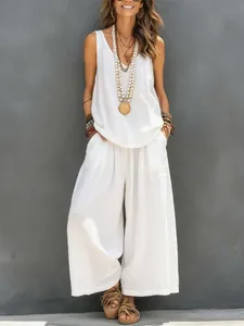 Full-body view of a woman wearing a white casual sleeveless linen tank top and wide-leg pants