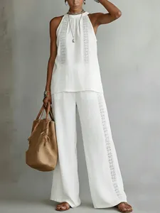 Full view of white hollow lace two-piece set with sleeveless top and wide-leg trousers.