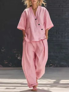 Detail view of a pink linen two-piece outfit featuring a V-neck top and loose trousers