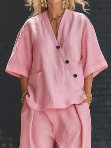 Detail view of a pink linen-textured two-piece set featuring a V-neck top and buttons