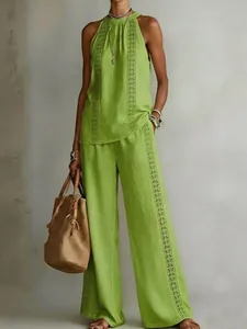 Detail view of women's lime green sleeveless top and wide-leg pants with geometric embroidery.