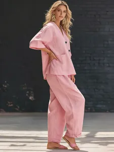 Casual pink linen-like two-piece set featuring V-neck button top and wide-leg trousers outfit