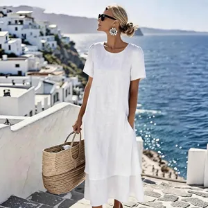 Full-length detail of a white double-layered short-sleeve dress worn on a sunny coastal vacation