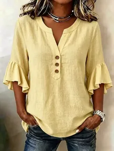 Détail d'une blouse jaune en coton et lin avec col en V, manches à volants et boutons