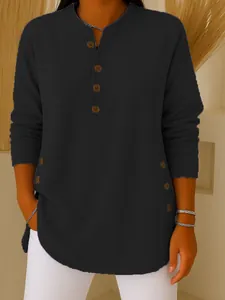 Close-up detail of women's black long sleeve Henley knit shirt with button accents
