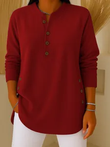 Close-up of a women's maroon knit Henley shirt with stylish side button detailing