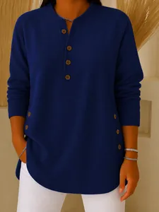 Close-up detail of navy blue knitted long sleeve top featuring decorative buttons
