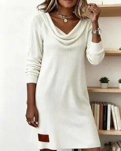 Primer plano de un vestido de punto acanalado blanco con elegante cuello vuelto y manga larga.
