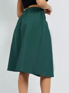 Back view detail of a dark green elastic waist A-line midi skirt with cargo pockets