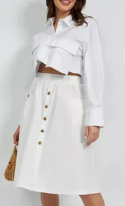 Detailed view of white A-line midi skirt with elastic waist and button front design