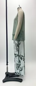 Side view of a sleeveless green double-layer vest and leaf print pants set for women.