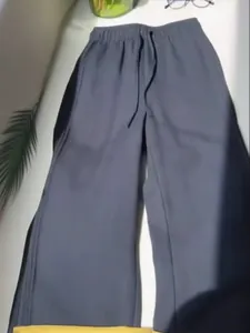 Detail view of dark grey wide-leg drawstring trousers for a casual holiday look.