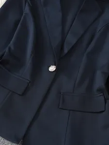 Detailansicht eines dunkelblauen Damenblazers mit elegantem Revers und Silberknopf