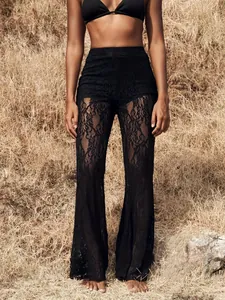 Detailed view of black high-waisted lace flared pants on a model in an outdoor setting