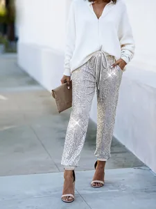 Dettaglio dei pantaloni jogger da donna con paillettes argento, coulisse e tasche laterali