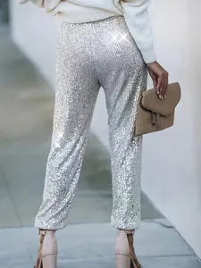 Dettaglio di pantaloni a gamba dritta con paillettes argento da donna per occasioni speciali