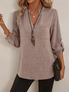 Vue détaillée d'une blouse vintage à col en V avec manches retroussées et une poche