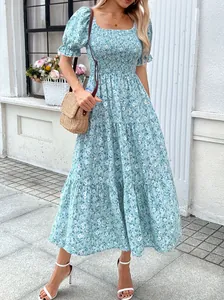 Blaue florale Midikleid mit Karree-Ausschnitt und gesmokter Taille in der Totalansicht.