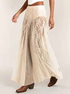 Close-up detail of a beige sheer lace maxi skirt with elegant floral and polka dot patterns.